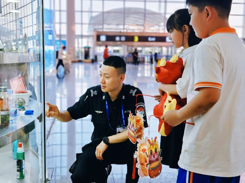 工作人員為小朋友講解哪些物品不能乘機.jpg